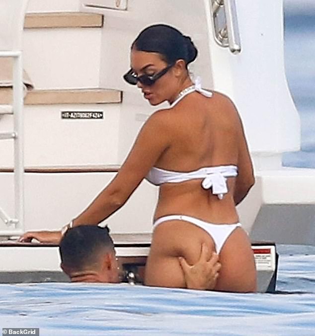 Georgina, 30, wowed in a white thong bikini that highlighted her peachy bottom - with Ronaldo unable to resist giving it a cheeky squeeze